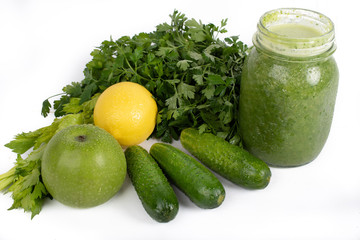 Jar of raw green vegetable smoothie juice with lemon, cucumbers, apple, apio and parsley, on white background 