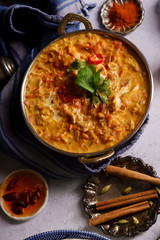 Indian cuisine: chicken tikka masala with rice and naan bread and spices.