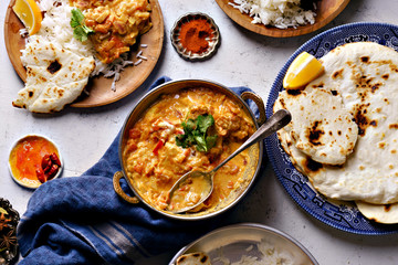 Indian cuisine: chicken tikka masala with rice and naan bread and spices.