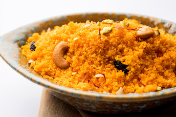 Badaam kesar shira / Sheera or almond saffron halwa, popular Indian dessert served in a bowl. selective focus
