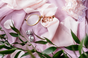 Wedding rings lie on a pink knitted heart in a wicker basket.