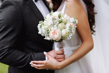 bride and groom are holding a wedding bouquet