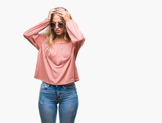 Beautiful young blonde woman wearing retro sunglasses over isolated background suffering from headache desperate and stressed because pain and migraine. Hands on head.
