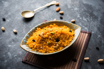 Badaam kesar shira / Sheera or almond saffron halwa, popular Indian dessert served in a bowl. selective focus