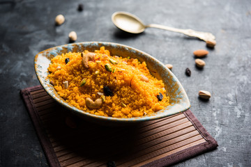 Badaam kesar shira / Sheera or almond saffron halwa, popular Indian dessert served in a bowl. selective focus