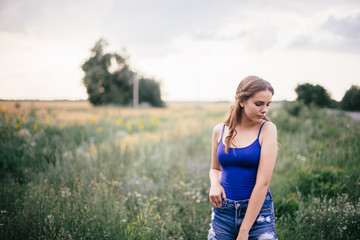 Beautiful girl in short shorts and in a blue T-shirt on the field