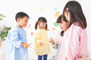 幼稚園・保育園・こども園で笑顔で楽しく遊ぶ児童と先生