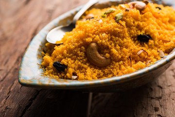 Badaam kesar shira / Sheera or almond saffron halwa, popular Indian dessert served in a bowl. selective focus