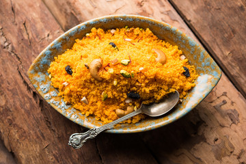 Badaam kesar shira / Sheera or almond saffron halwa, popular Indian dessert served in a bowl. selective focus