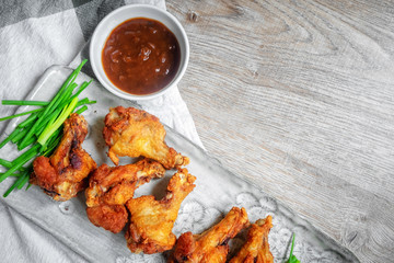 Fried chicken with BBQ sauce on a wooden background.