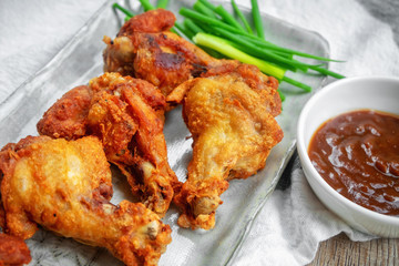 Fried chicken with BBQ sauce on a wooden background.