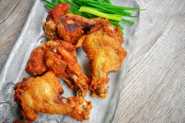 Fried chicken with BBQ sauce on a wooden background.