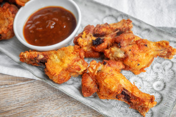 Fried chicken with BBQ sauce on a wooden background.