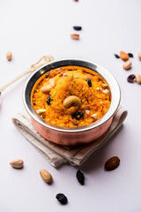 Badaam kesar shira / Sheera or almond saffron halwa, popular Indian dessert served in a bowl. selective focus