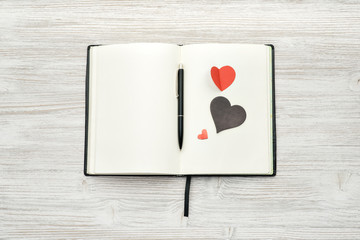Notebook with heart and pen on wooden background mock up top view. Valentines day. 14 february.