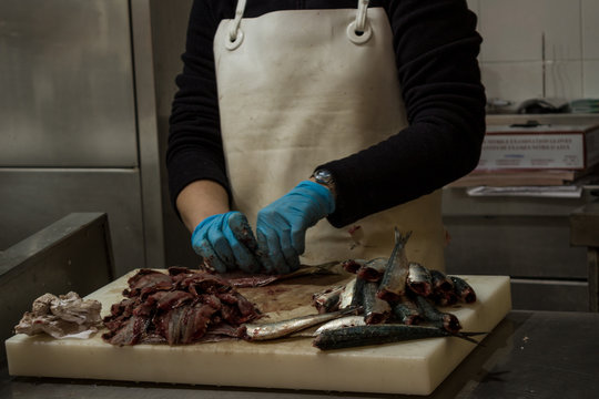 Trabajadora quitando las tripas del pescado