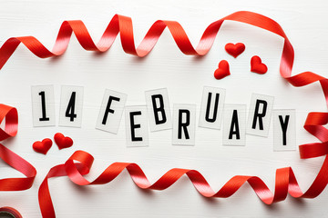 14 February calendar date with red hearts and ribbon band top view. Valentines Day