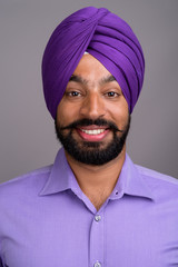 Face of Indian Sikh businessman wearing turban and smiling