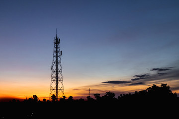 Silhouette high voltage electricity pylon at time sunset.