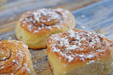 Delicious cinnamon rolls on wooden background.Fresh pastry.
