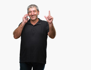Fototapeta premium Handsome senior man talking on smartphone over isolated background surprised with an idea or question pointing finger with happy face, number one