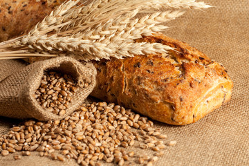 Retro bread in rustic style background.Fresh traditional bread on wooden ground with flour in a sack.
