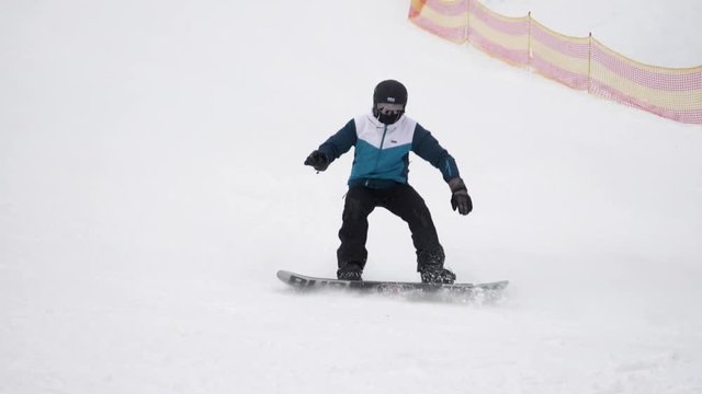 Snowboarder going down from mountain slope. Winter vacation
