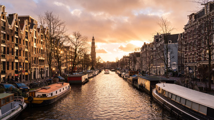 Famous channels (grachten) of Amsterdam, Netherlands, at sunset on a cloudy winter day.