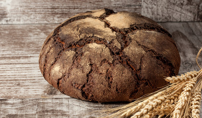 Retro bread in rustic style background.Fresh traditional bread on wooden ground with flour in a sack.