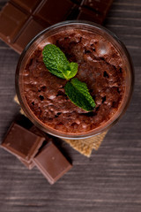 Chocolate, coffee, milk, banana shake on wooden background. Smoothie with mint. Milkshake. Protein diet. Healthy food and drink concept.