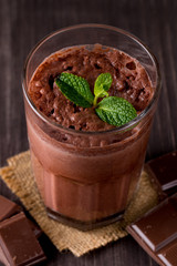 Chocolate, coffee, milk, banana shake on wooden background. Smoothie with mint. Milkshake. Protein diet. Healthy food and drink concept.