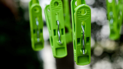 Green clothespins hanging in a garden in strong sunlight environment