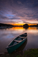 Naklejka na ściany i meble Canoe on the lake during sunset