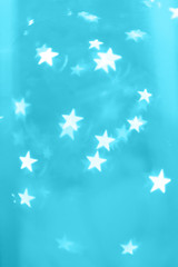 Glowing stars on blue cyan background. Bokeh abstract pattern that can be used as backdrop.