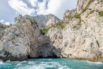 Fototapeta premium Bei einer Umrundung der Insel Capri mit einem Boot eröffnen sich die schönsten Perspektiven auf die Insel. Die bekanntesten Attraktionen der Insel sind die Grotten und die Felsenformationen.