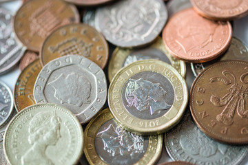 Close up of fractional currency coins of pound sterling such as Ten pence and one pound . Saving and business concept.