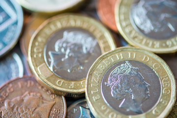 Close up of fractional currency coins of pound sterling such as Ten pence and one pound . Saving and business concept.