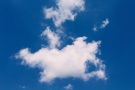 Clouds shape patterns with reflection on clear blue sky background in summer day