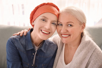 Mature woman visiting her daughter with cancer indoors