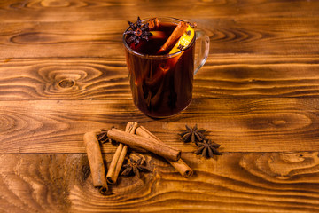 Cup of mulled wine with cinnamon on wooden table