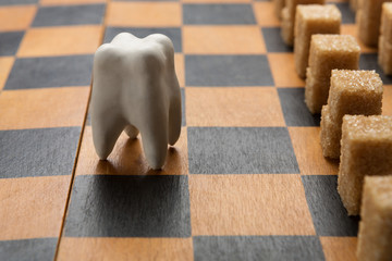Healthy tooth against sugar army on chessboard