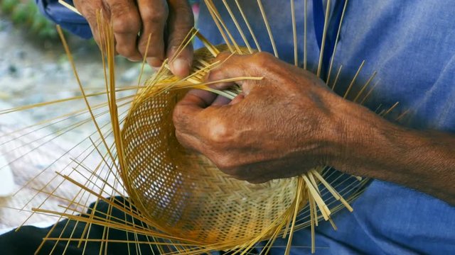 hand weaving a bamboo basket