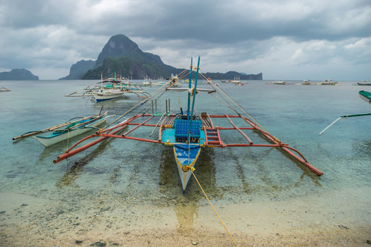 Fishing boat stranded and moored at the beach in a rainy morning in El Nido, Palawan, Philippines.