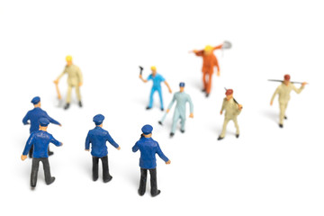 Fototapeta na wymiar Miniature people : Police and an angry mob on white background