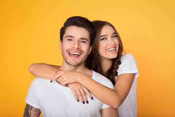 Happy casual couple embracing, posing to camera