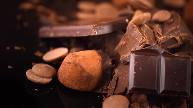 Chocolate. Assorted chocolate sweets and candies rotated over dark background. Confectionery concept. Rotation. Slow motion 4K UHD video 3840X2160