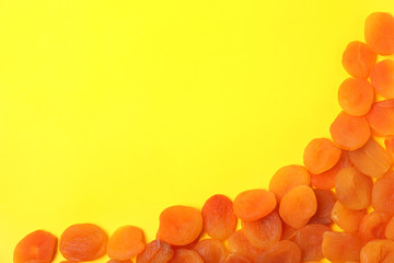 Dried apricots on color background, top view with space for text. Healthy fruit