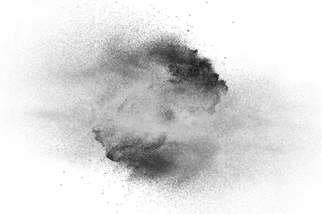 Poster Zwart poeder explosie op witte achtergrond. Zwarte stofdeeltjes spatten. © Pattadis
