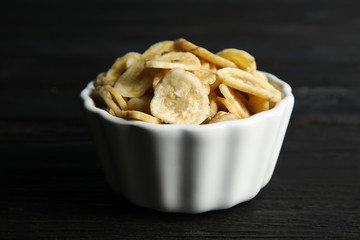 Bowl with sweet banana slices on wooden  table. Dried fruit as healthy snack