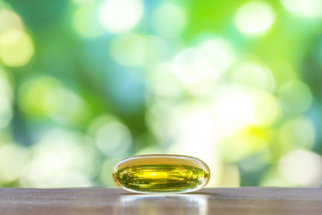 fish oil capsule on wooden table with natural background